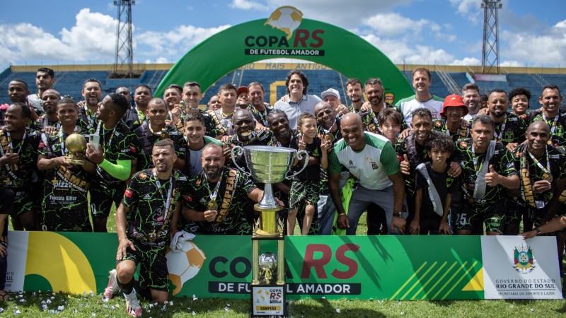 Foto possa de vários jogadores reunidos após receberem o troféu da primeira Copa RS de Futebol Amador.