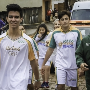 Estudantes acendem a tocha e acompanham o primeiro condutor do símbolo olímpico em cada cidade