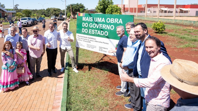 Governador Eduardo Leite e secretários de Estado posam para foto ao lado de uma placa que anuncia mais uma obra do governo do Estado. A cena foi registrada durante visita ao município de Inhacorá, onde recursos do Pavimenta e do Avançar no Turismo viabilizaram asfaltamento de três vias da cidade.