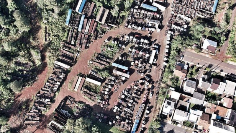 Tomada área de um pátio de terra com caminhões apreendidos