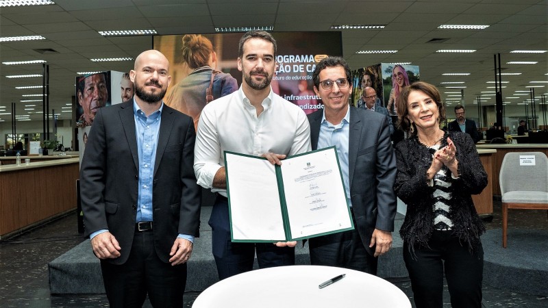 O governador Eduardo Leite segura o documento assinado para criação da parceria público-privada que realizar melhorias na infraestrutura escolar. Ele está no centro da imagem. À sua esquerda está o secretário de Parcerias e Concessões, Pedro Capeluppi, e à direita o diretor da SP Parcerias, Guilherme Bueno, e a secretária da Educação, Raquel Teixeira. 