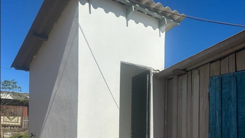 Foto da unidade entregue. Um módulo todo em branco e telhado à vista comum tanque do lado esquerdo.