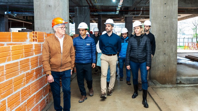 Leite vistoria obras no Pronto Socorro Regional de Pelotas. Ele está ao centro rodeado por diversas pessoas caminhando pela parte interna da obra.