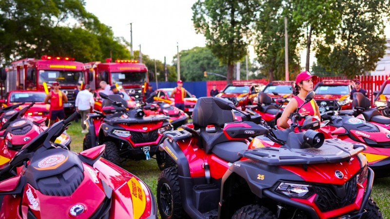 Imagem dos diversos veículos entregues estacionados em um grande espaço gramado. Mais {a frentes estão os quadriciclos e ao fundo podem ser vistos dois caminhões e três caminhonetes. Há em alguns pontos pessoas ao lado dos veículos.