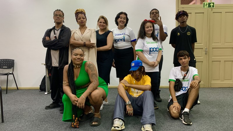 Foto posada com os jovens que participaram do evento. Quatro mulheres e três homens estão em pé atrás. Uma mulher e dois homens estão agachado À frente.
