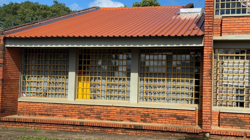 Imagem da fachada da Escola Tricentenário, com destaque para uma parte do telhado recém substituído.