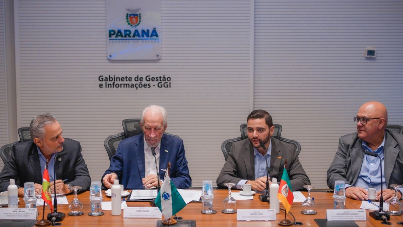 Reunião sobre malha ferroviária Sul. Sentados à uma mesa, são vistos de frente Gabriel Souza e outros três homens.
