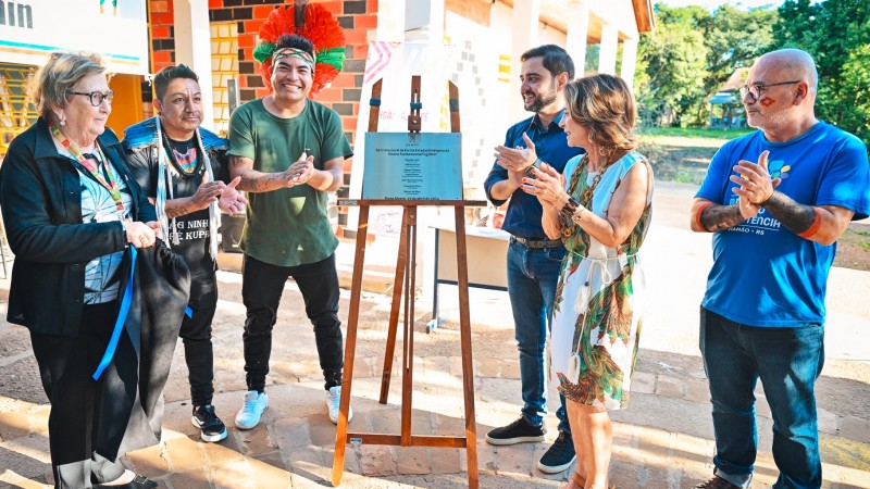 Gabriel Souza e as outras cinco pessoas aplaudem a placa que maraca a entrega da reforma na escola indígena Fag Nhin.