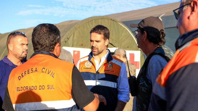 Leite em Eldorado do Sul conversando com quatro integrantes da Defesa Cilvil. 