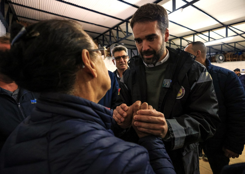 Leite Visita Putinga e conversa com uma mulher olhando nos olhos dela e segurando as mão dela. Ela está de costas e Leite de frente.