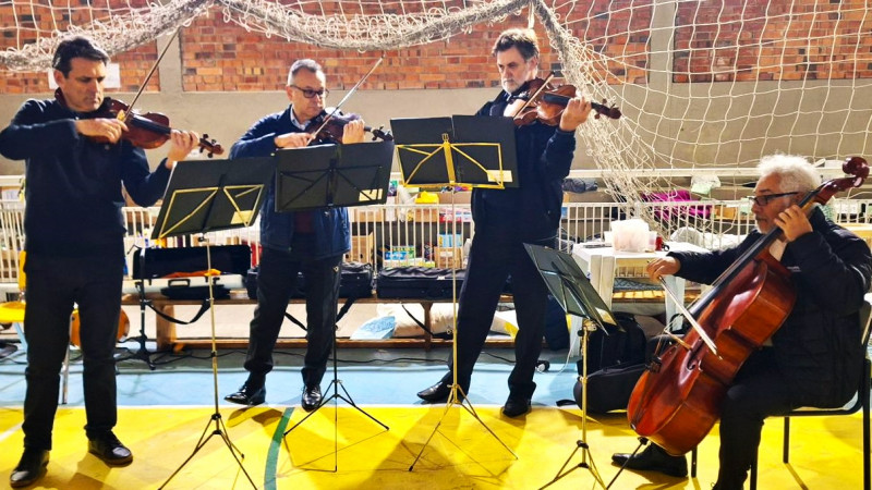 Quarteto de cordas da OSPA fazendo uma apresentação em um ginásio que serve de abrigo para desalojados pela pelas enchentes.