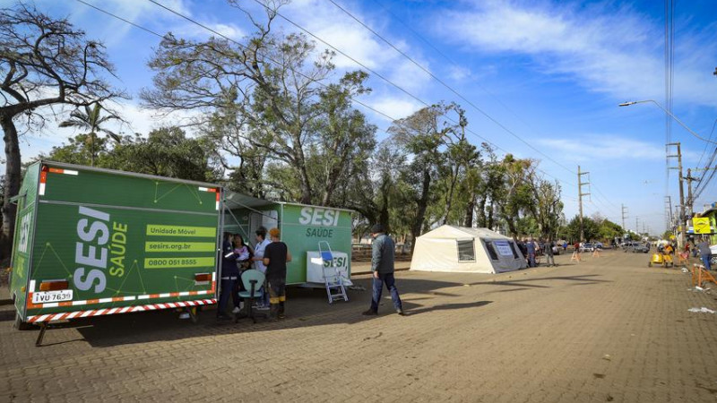 Tenda de campanha instalada em uma rua e onde está ocorrendo atendimento a uma pessoa