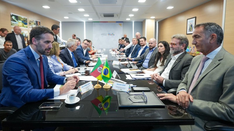 Reunião como ministro Waldez Góes. Na imagem uma mesa bem grande com diversas pessoas sentadas à direita e à esquerda. Próximos e de frente um para outro estão o governador e o ministro.