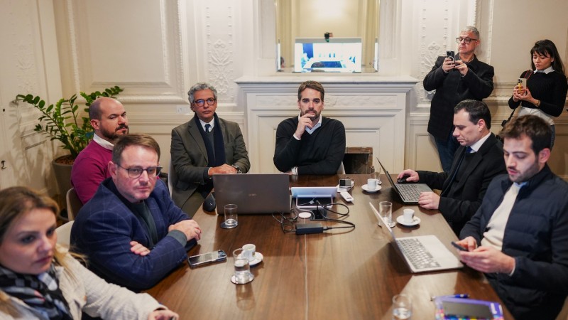 Leite, de frente, na cabeceira de uma mesa e outras pessoas dos dois lados acompanhando a reunião.