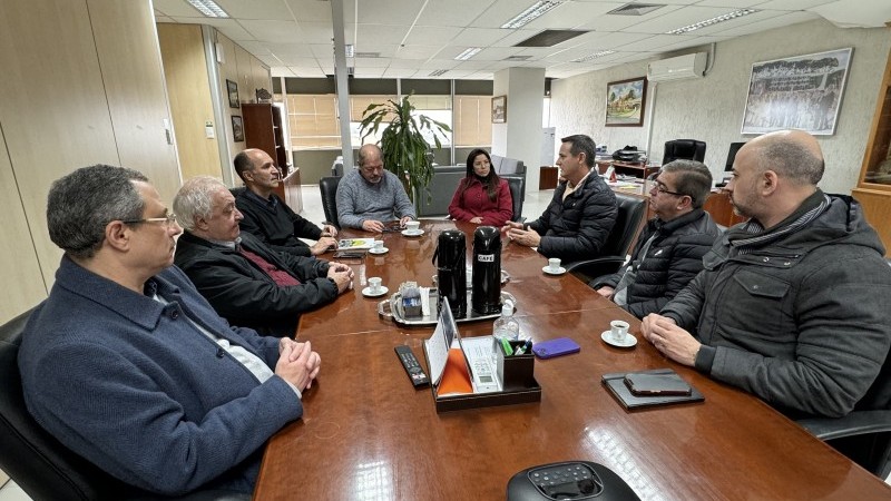 Imagem de oito pessoas reunidas em torno de uma mesa.