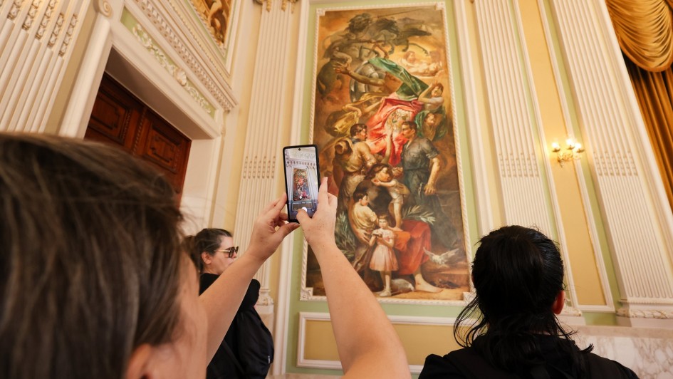 Visitantes fotografando um dos painéis do Palácio Piratini.