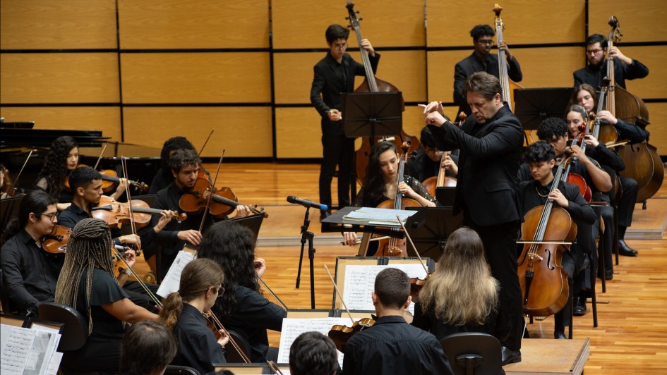 Imagem de parte dos instrumentistas da Ospa Jovem se apresentando no encerramento do Dia do Patrimônio Cultural 2024. O maestro também aparece gesticulando na foto.