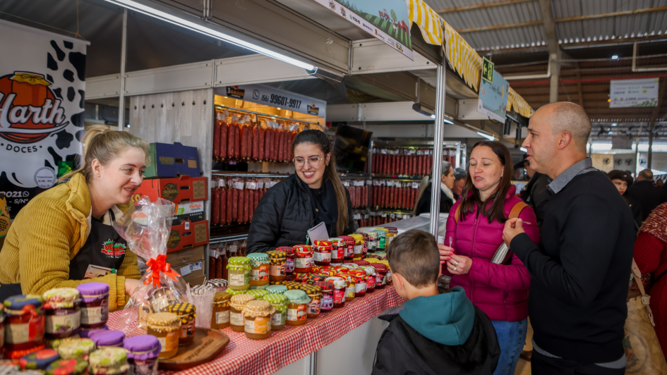 Pessoas fazendo compras em uma banca do Pavilhão da Agricultura Familiar na Expointer 2024.