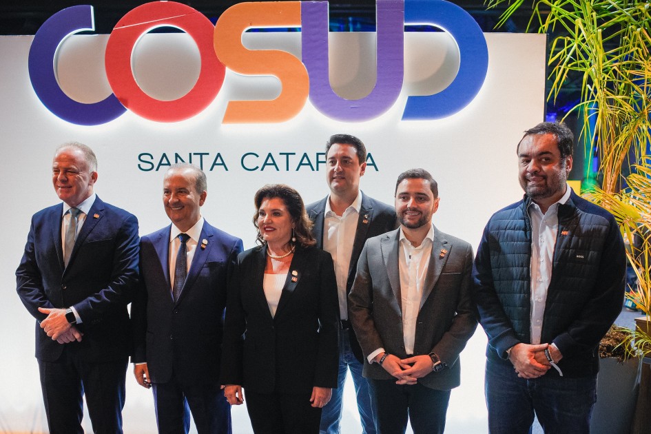 Foto posada em frente a um painel do Cosud estão Gabriel e outros cinco líderes dos Estados participantes
