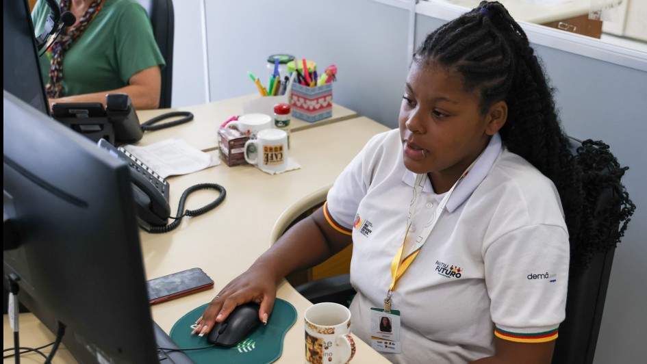 Jovem negra operando um computador.
