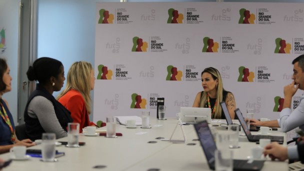 Pessoas sentada em volta de uma mesa em reunião com Banco Mundial.