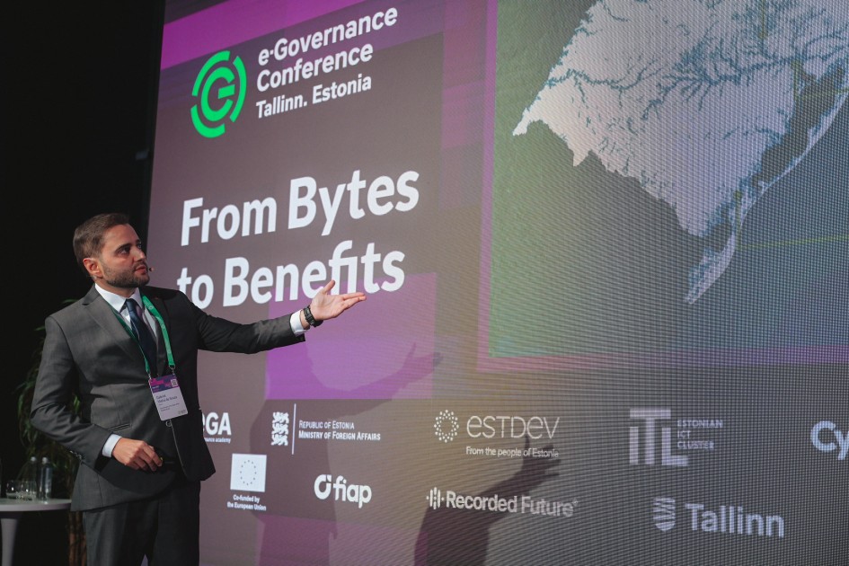 Gabriel apontando a tela e falando na e-Governance Conferece na Estônia em 2025.