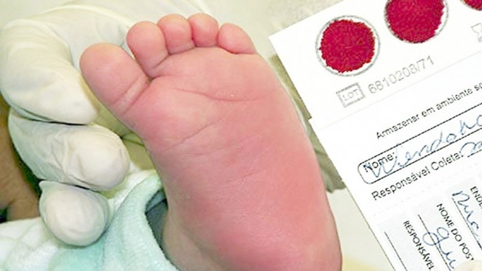 Imagem de um pé de bebê e de uma cartela com o sangue coletado ao lado.