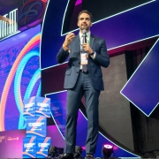 Leite em close sobre o palco falando ao microfone na Gramado Summit 2025.
