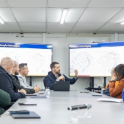A imagem mostra o governador Eduardo Leite participando de uma reunião técnica com prefeitos e autoridades estaduais, diante de telas que exibem mapas com a “Situação hidrológica”. O encontro, realizado em 27 de junho de 2025, teve como objetivo alinhar estratégias de prevenção diante da previsão de um novo evento climático extremo no Rio Grande do Sul. O ambiente transmite seriedade e foco na gestão de riscos.