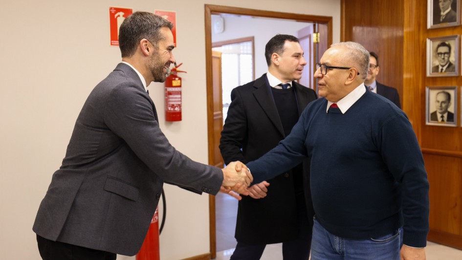 A imagem mostra, em primeiro plano, o governador Eduardo Leite cumprimentando o conselheiro do TCE, Estilac Xavier. Eles estão apertando as mãos e sorrindo.