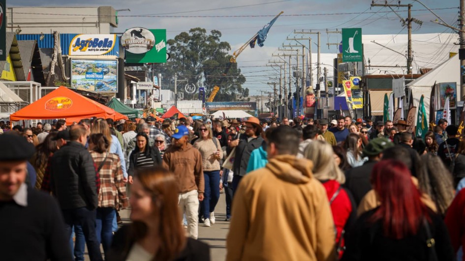 Foto mostra os corredores do parque da Expointer lotados de pessoas caminhando.