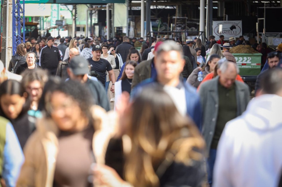 Foto mostra um corredor da feira com muitas pessoas caminhando.