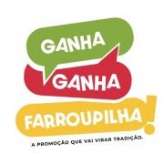 A imagem é um cartaz promocional com fundo colorido em tons de verde, amarelo, vermelho e azul. O texto principal, em letras grandes e brancas, é "GANHA GANHA FARROUPILHA", com uma palavra abaixo da outra. Na parte inferior, contém a frase em letras pretas, bem menores: "A PROMOÇÃO QUE VAI VIRAR TRADIÇÃO.". O estilo visual remete a decoração tradicional da cultura gaúcha.