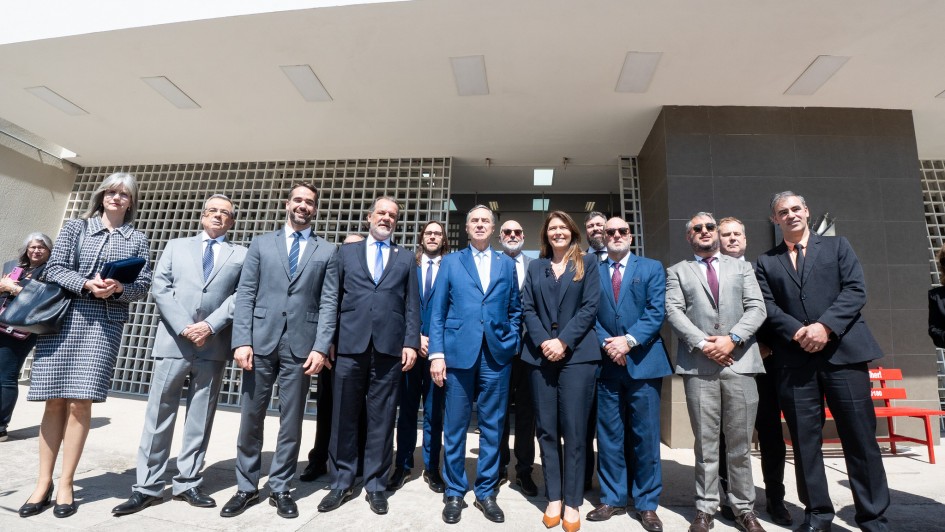 Um grupo de autoridades posa para foto em frente ao prédio identificado como Centro de Justiça. Entre eles estão o governador Eduardo Leite, de terno cinza, e o presidente do STF, ministro Luís Roberto Barroso, de terno azul, posicionados lado a lado no centro da imagem.