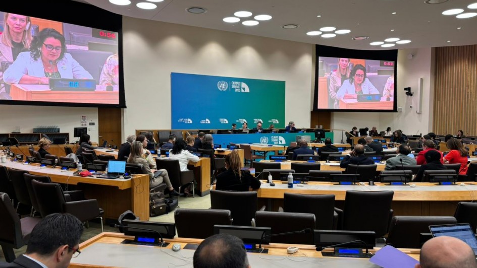 A imagem mostra uma sessão em andamento nas Nações Unidas (ONU), possivelmente durante uma cúpula climática, como indicado pelo painel azul ao fundo com o texto "Climate Ambition Summit 2023". A sala está cheia de delegados e participantes sentados em mesas organizadas em formato semicircular, típicas de sessões da ONU.

Em destaque, dois telões mostram uma mulher discursando com o microfone ligado e um cronômetro marcando o tempo da fala (0:56). A plaquinha à sua frente indica "ICLEI", uma organização global voltada para sustentabilidade local. A plateia acompanha atentamente, com notebooks e documentos abertos, evidenciando o caráter técnico e diplomático do evento. A atmosfera é formal e voltada à discussão de políticas internacionais relacionadas ao clima.