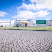 A imagem mostra a fachada do Hospital Regional de Santa Maria, identificado por uma placa verde com letras brancas que diz: “HOSPITAL REGIONAL DE SANTA MARIA”. O prédio é branco, com linhas simples e modernas, e possui uma entrada coberta por uma estrutura em formato triangular. 