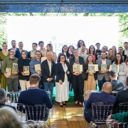 Uma foto de um Uma foto de um grupo grande de pessoas (cerca de 30, homens e mulheres) posando em um palco após receberem premiações. Eles estão de pé, sorrindo, e a maioria segura placas ou troféus retangulares com ilustrações. Eles são os vencedores do Prêmio Sema-Fepam de Jornalismo Ambiental 2025.

O palco é decorado com um grande painel de LED central que está totalmente iluminado com uma luz branca forte, e é emoldurado por painéis laterais que projetam imagens de folhagem verde, dando a impressão de natureza. Na frente do palco, há uma plateia sentada em cadeiras transparentes (de acrílico) e escuras. O ambiente é formal, mas com um toque de evento corporativo ou premiação.