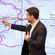 Imagem mostra o governador do Rio Grande do Sul, Eduardo Leite, apontando, sobre mapa projetado em telão, a malha rodoviária envolvida no projeto de concessões do governo estadual.