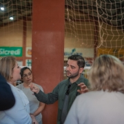 Foto mostra o vice-governador Gabriel Souza gesticulando enquanto conversa com membros da comunidade escolar de Independência, durante visita ao município.