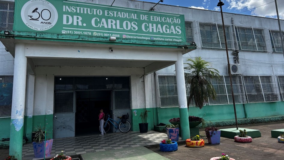 A imagem mostra a fachada de uma escola, em tons verdes e brancos. Na frente, se lê "Instituto Estadual de Educação Dr. Carlos Chagas". 