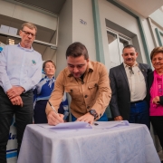 Foto mostra vice-governador Gabriel Souza assinando documento sob o olhar de integrantes da comunidade