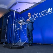 Foto mostra governador Eduardo Leite de pé em discurso na 56ª Convenção da Confederação Israelita do Brasil (Conib)