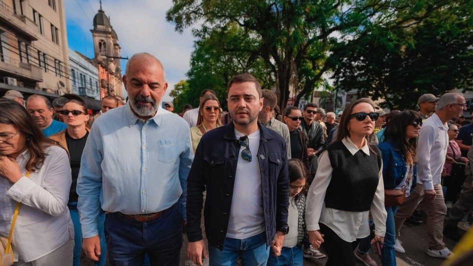 Foto mostra vice-governador Gabriel Souza caminhando duranta a romaria ao lado de sua esposa Talise e de sua filha Dora