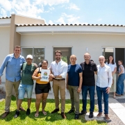Foto mostra o governador Eduardo Leite, ao centro, entre grupo de pessoas, durante cerimônia para entrega de moradias em Feliz