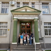 Foto mostra fachada do Colégio Onofre Pires, em Santo Ângelo com equipe da 14ª Coordenadoria Regional de Obras Públicas posando na entrada do prédio
