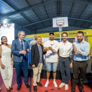 Um grupo de autoridades e convidados posa em uma quadra esportiva coberta durante um evento de entrega de moradias. No centro da imagem, pessoas sorriem e seguram simbolicamente uma chave.
O governador Eduardo Leite aparece na foto — ele está ao centro-direita, de camisa branca, sorrindo.