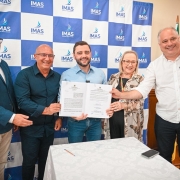 Foto mostra vice-governador Gabriel Souza, em ato de assinatura, com autoridades do Estado e município de Tramandaí