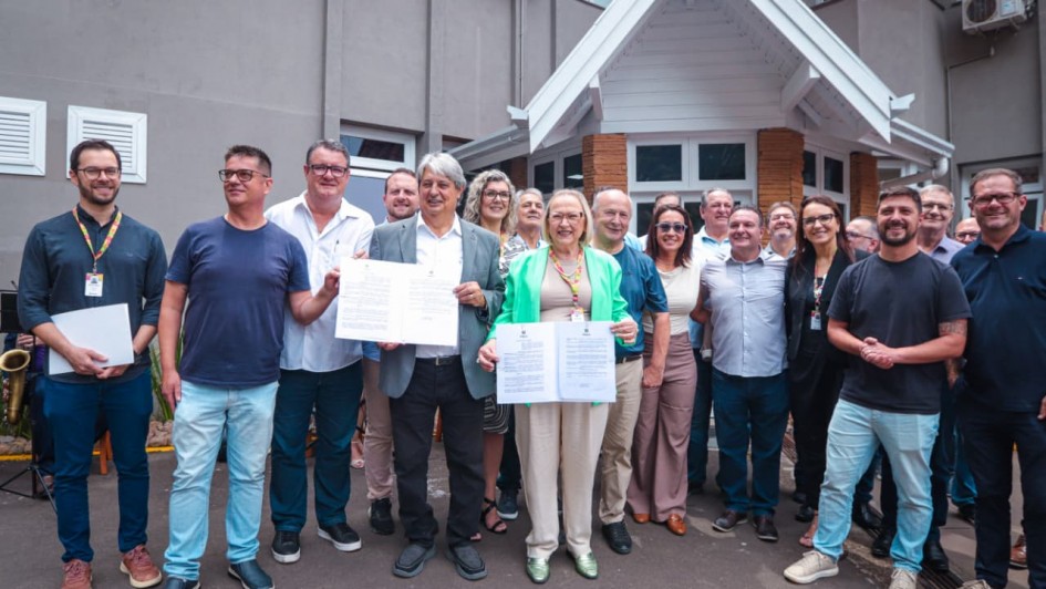 Foto mostra grupo de pessoas em ato de assinatura, tendo, ao centro, a secretária da Saúde Arita Bergmann 