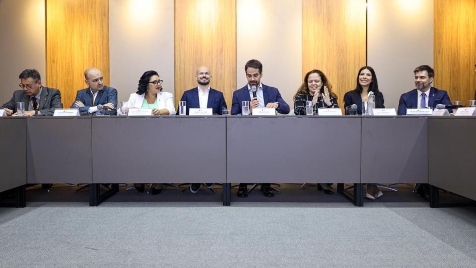 Governador Eduardo Leite com secret&aacute;rios e autoridades est&atilde;o sentados lado a lado numa mesa.