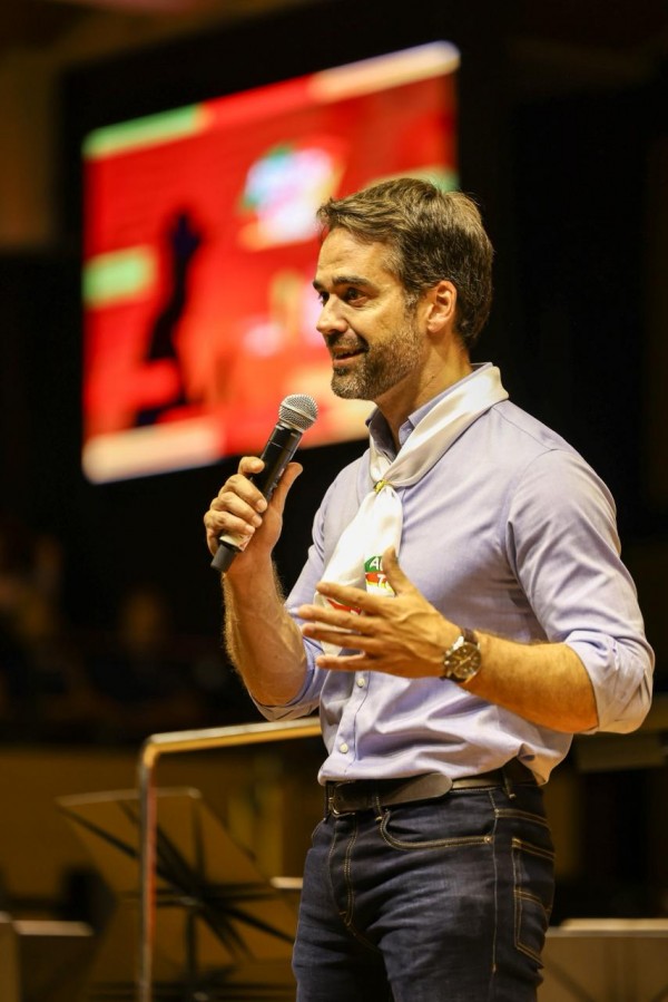 Foto mostra governador Eduardo Leite falando ao público